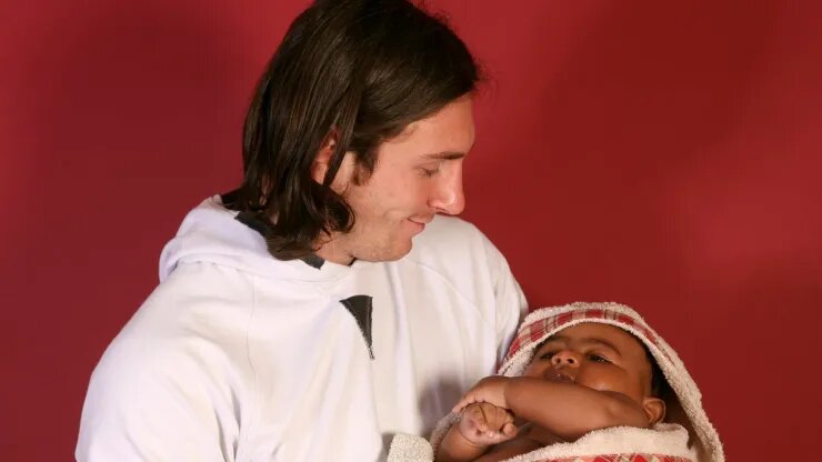 A young Lionel Messi holding a baby Lamine Yamal